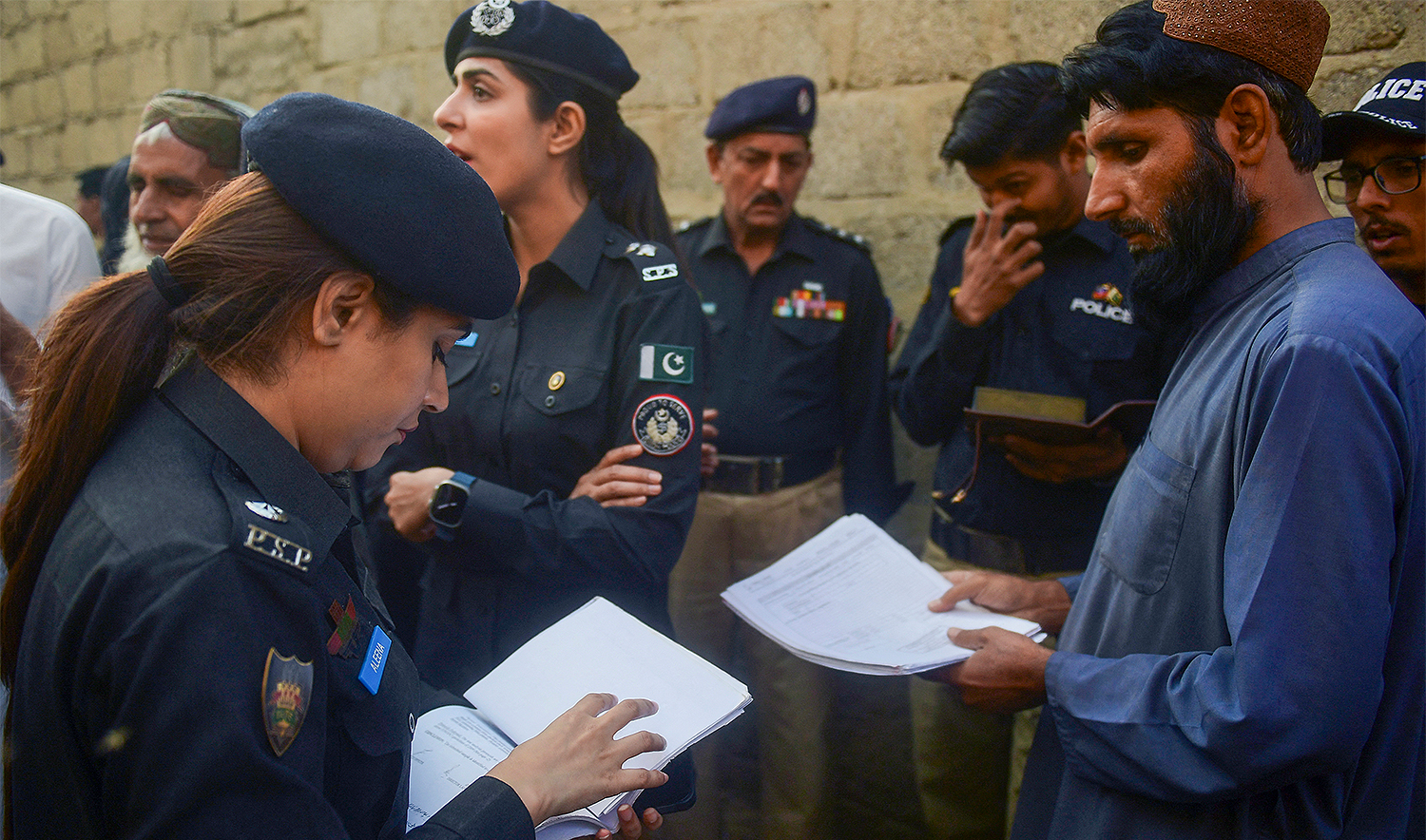 Police personnel check documents of Afghan refugees during a search operation to identify alleged illegal immigrants, on the outskirts of Karachi on November 17, 2023. (AFP/File)