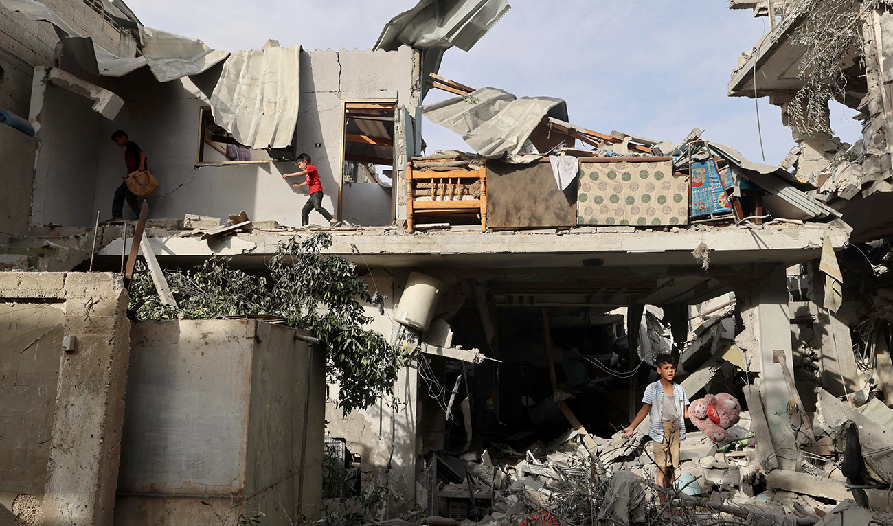 Palestinian youths search the rubble of a building hit in overnight Israeli bombardment in Rafah in the southern Gaza Strip, on April 25, 2024. (AFP/File)