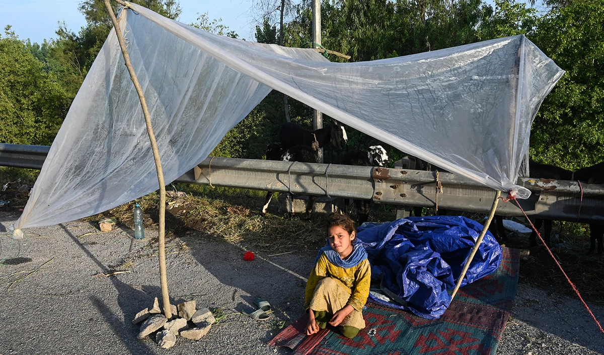 A displaced girl waits for assistance in her tent at a makeshift camp after fleeing from her flood hit home following heavy rains in Charsadda district of Khyber Pakhtunkhwa province on April 17, 2024. (AFP)