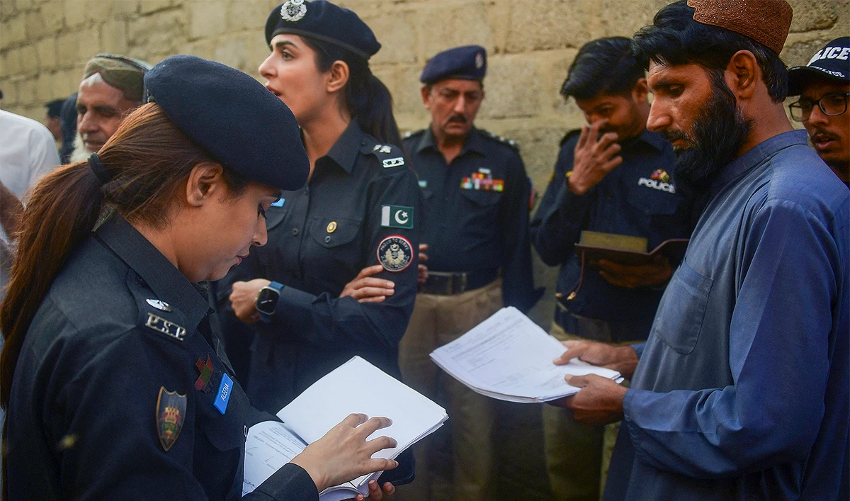 Police personnel check documents of Afghan refugees during a search operation to identify alleged illegal immigrants, on the outskirts of Karachi on November 17, 2023. (AFP/File)