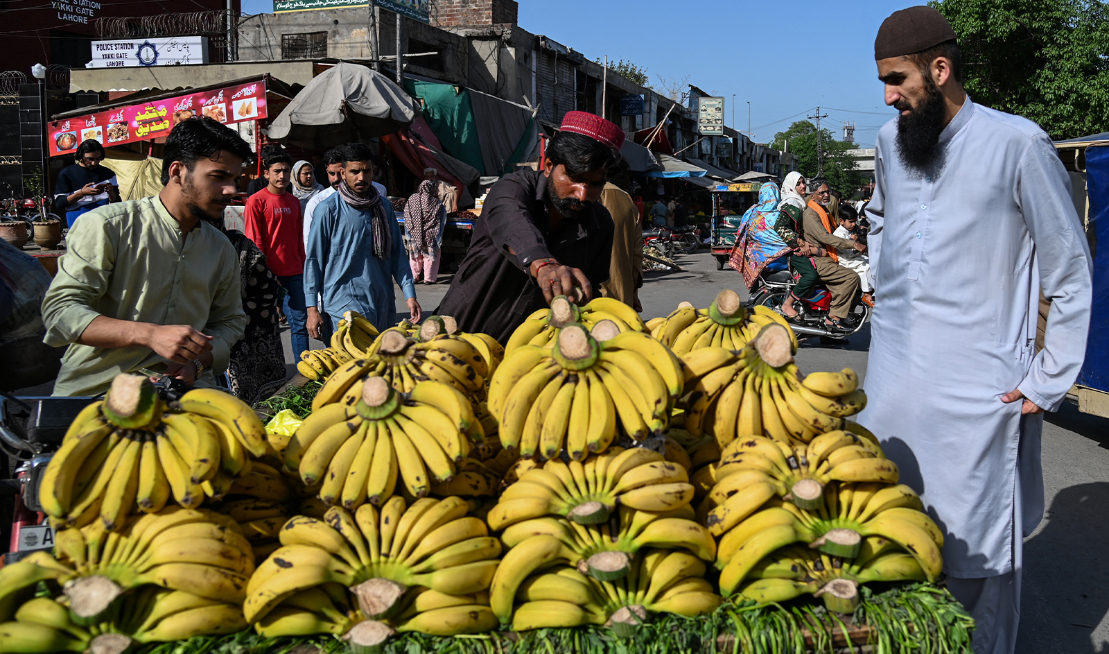 A vendor sells bananas on a cart along a street in Lahore on March 31, 2024. (AFP)