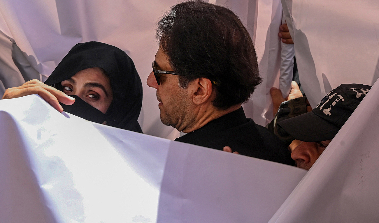 In this file photograph, taken on May 15, 2023, former Pakistan Prime Minister Imran Khan (C) with his wife Bushra Bibi (L) arrive to appear at a high court in Lahore. (AFP/File)