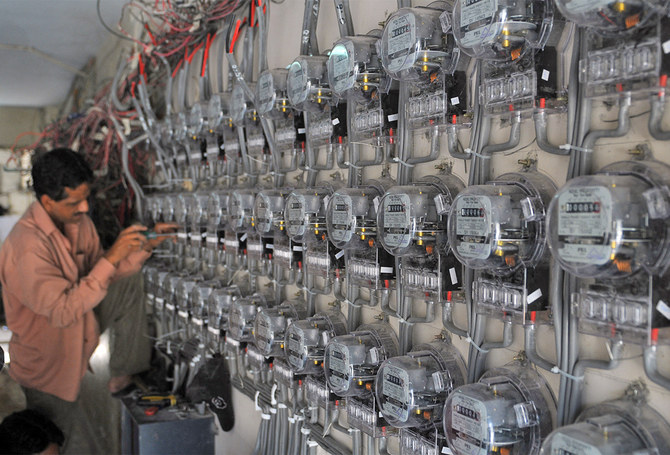 A technician fixes new electricity meters at a residential building in Karachi, Pakistan, on May 13, 2010. (AFP/File)