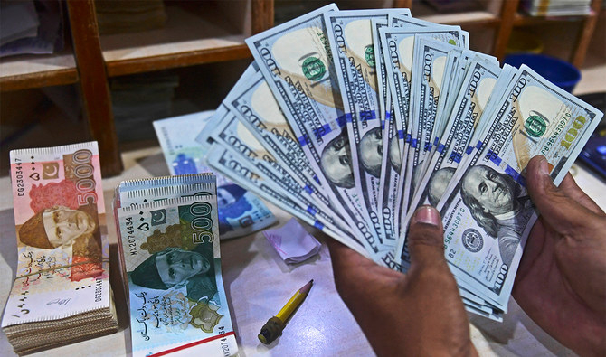 A foreign currency dealer counts US dollars at a shop in Karachi, Pakistan, on May 19, 2022. (AFP)