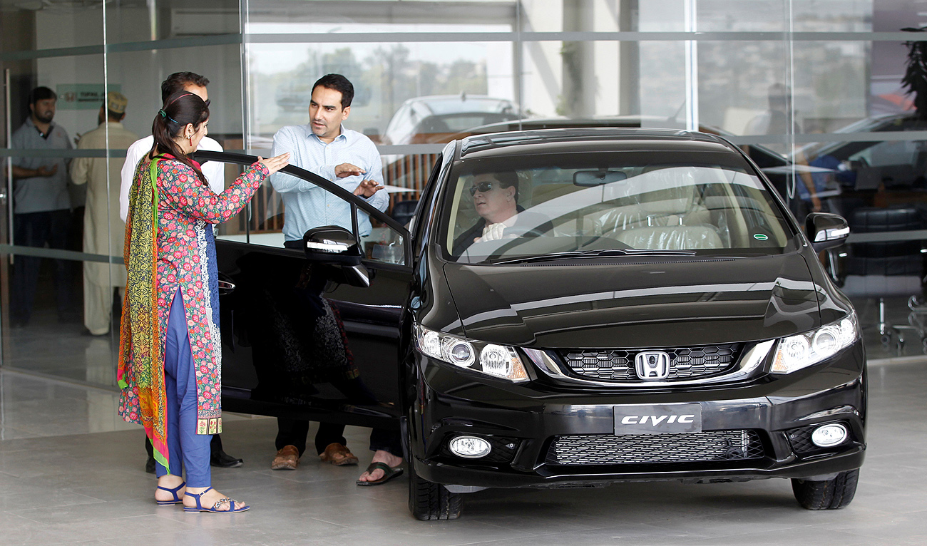 In this file photo, taken on June 18, 2016, a customer speaks with salespeople at a car dealership in Rawalpindi. (REUTERS/File)