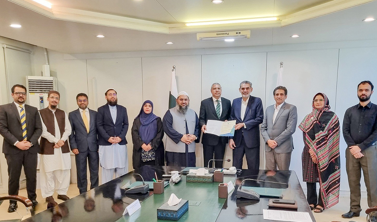Officials pose for a group photograph as Akif Saeed, chairman of the Securities and Exchange Commission of Pakistan, handing over the license to Rizwan Hussain, chief executive officer of the Salaam Family Takaful Limited, for Pakistan’s “first ever” digital Islamic life insurance provider in Karachi on May 17, 2024. (APP)
