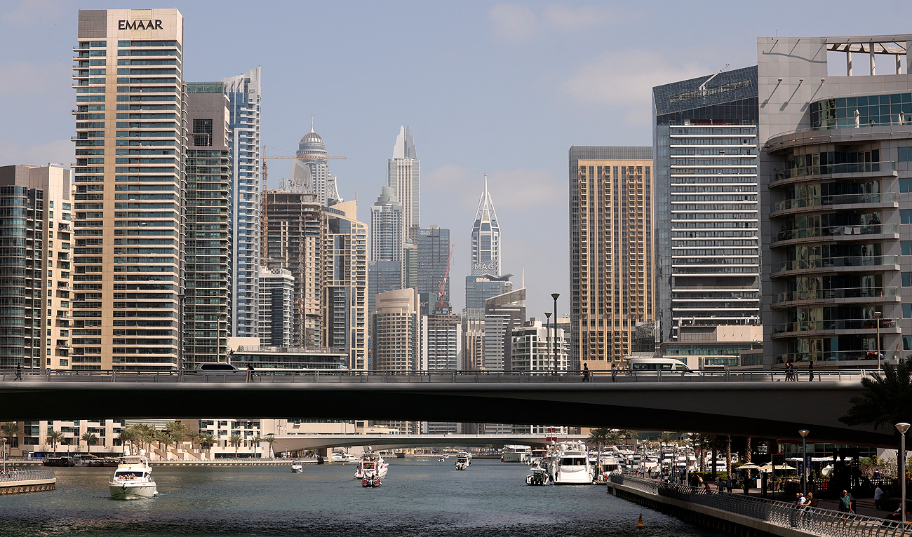 Boats sail along the Dubai Creek surrounded by high-rise buildings in the Gulf emirate, on February 18, 2023. (AFP/File)