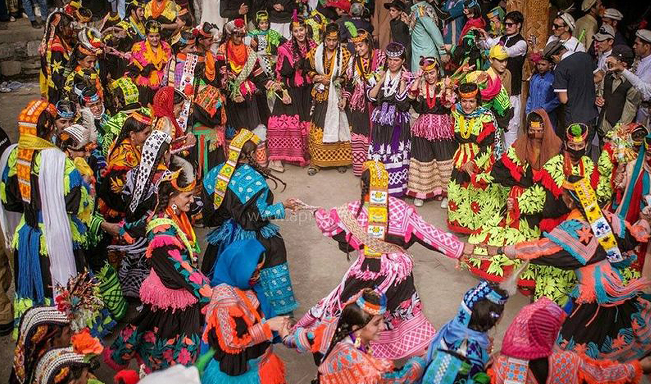 In this photograph, taken and released by the Associated Press of Pakistan on May 15, 2024, Kalash people perform traditional dance during the Chilam Joshi festival in the Rumbur valley of Kalash in Chitral. (APP)