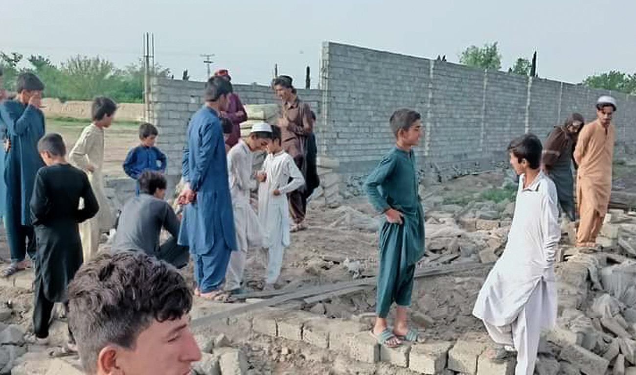 People gather outside the damaged school after militants’ set this government-run higher secondary school on fire in South Waziristan district on May 17, 2024. (Photo courtesy: District Police Wana)