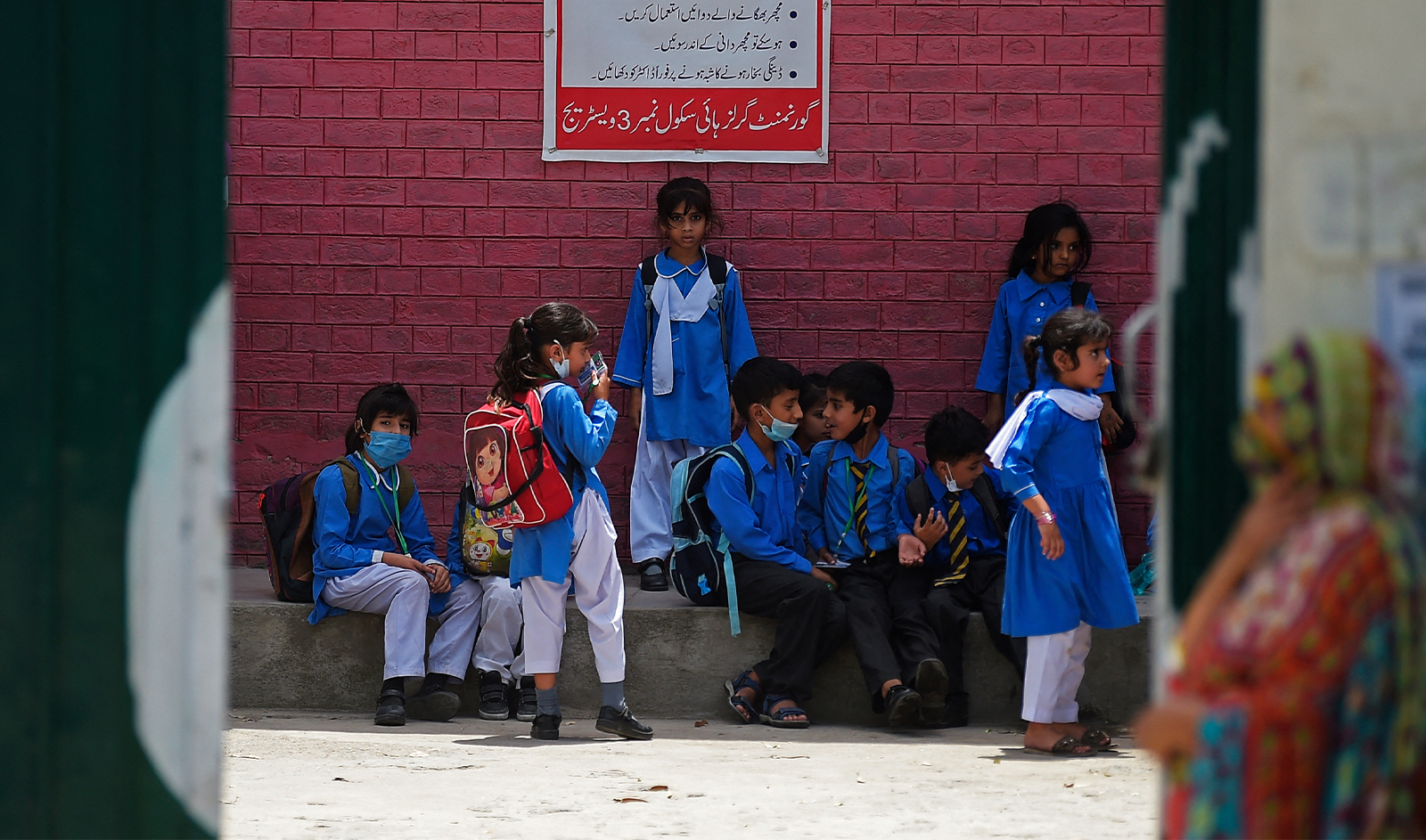 Students wait under a shade for the transport at a school on a hot summer day in Rawalpindi on June 10, 2021. (AFP/File)