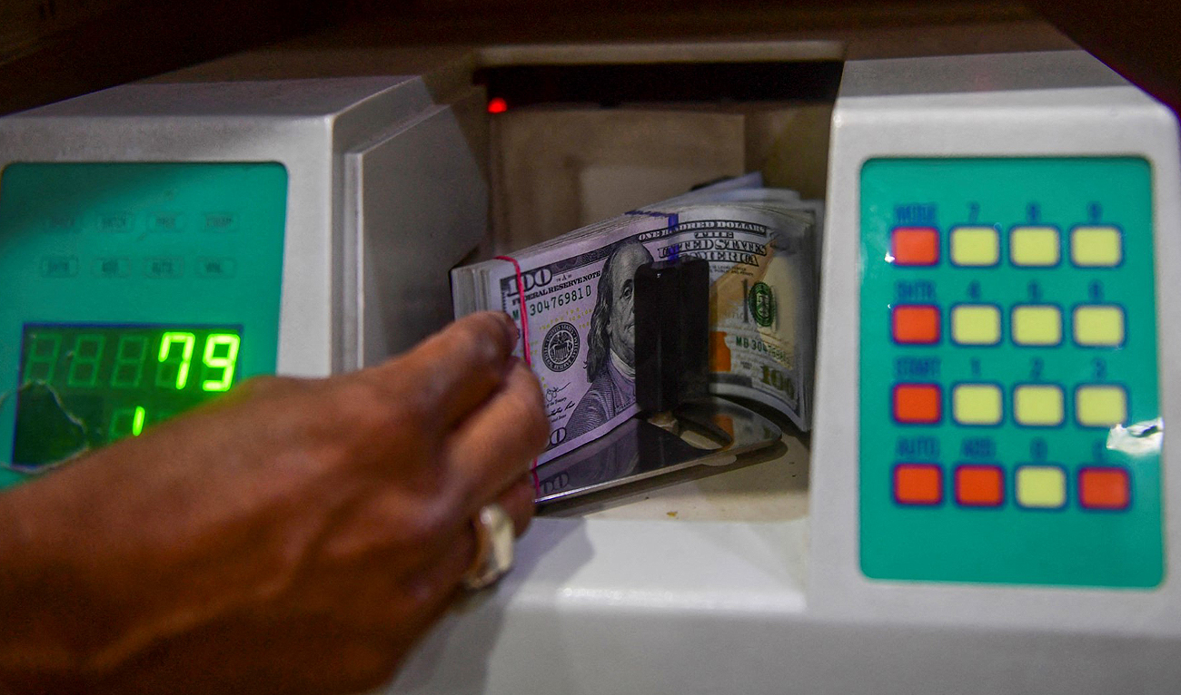 In this file photograph, taken on May 19, 2022, a foreign currency dealer counts US dollars at a shop in Karachi. (AFP/File)