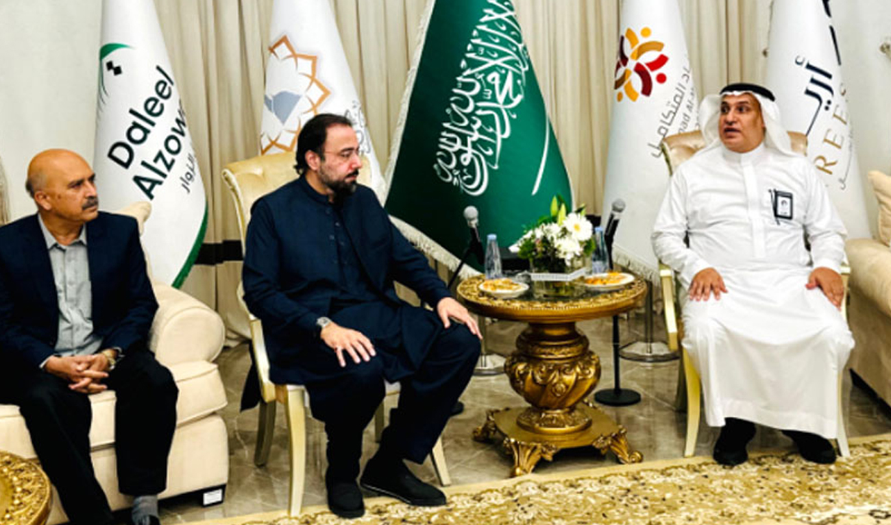 This handout photograph, taken and released by Radio Pakistan on May 17, 2024, shows Religious Affairs Minister Chaudhry Salik Hussain (second, left) with Esam Damyati (right), CEO of Adillah Company, in Madinah. (Radio Pakistan)