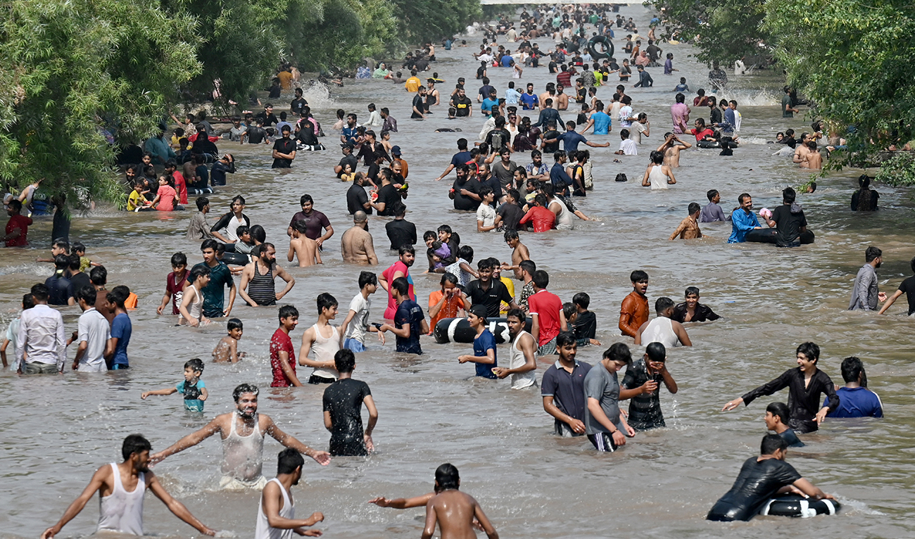 People take a dip in a canal to cool off on a hot summer afternoon in Lahore on May 19, 2024, amid the ongoing heatwave. (AFP)