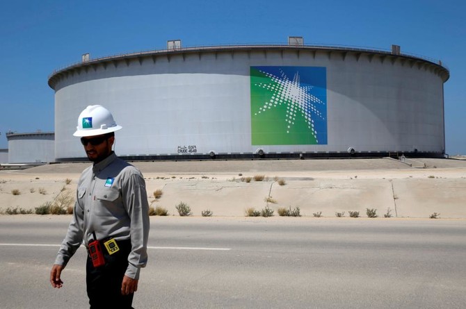 An Aramco employee walks near an oil tank at Saudi Aramco's Ras Tanura oil refinery and oil terminal in Saudi Arabia May 21, 2018. (REUTERS)