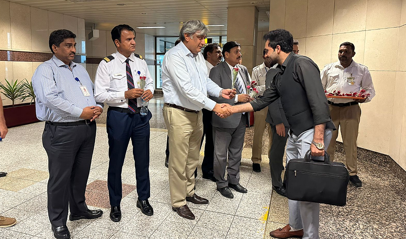 In this handout photograph, taken and released by Pakistan International Airlines, officials from Pakistan's national airline welcome students arriving from Bishkek via a special PIA flight at the Allama Iqbal International Airport in Lahore on May 21, 2024, days after mobs in Kyrgyz capital attacked foreign students following a brawl with migrants. (Photo courtesy: PIA)