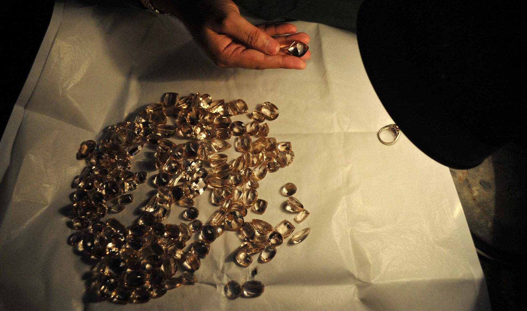In this photograph taken on June 24, 2014, a Pakistani craftsman checks a gemstone at a workshop in Peshawar. (AFP/File)