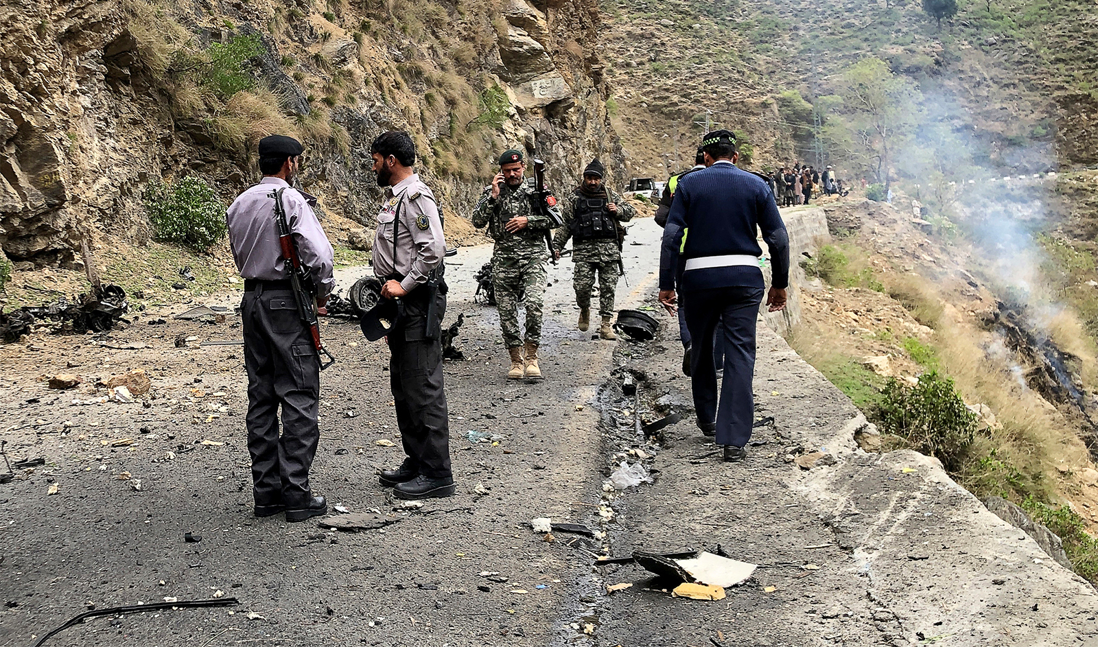 Security personnel inspect the site of a suicide attack near Besham city in the Shangla district of Khyber Pakhtunkhwa province on March 26, 2024. (AFP)
