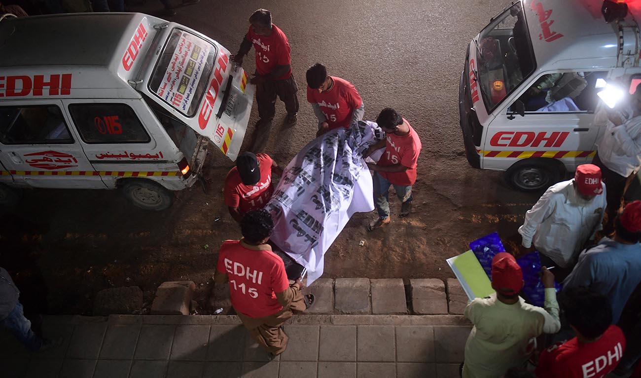 Edhi volunteers, a social welfare non-profit foundation, shift the remains of a victim to a morgue in Karachi early on October 13, 2022. (AFP/File)