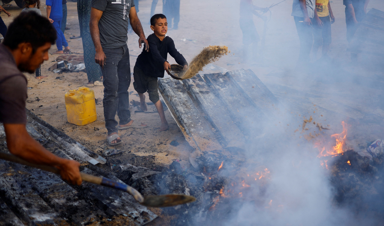 Palestinians put out a fire at the site of an Israeli strike on an area designated for displaced people, in Rafah, in the southern Gaza Strip on May 27, 2024. (REUTERS)