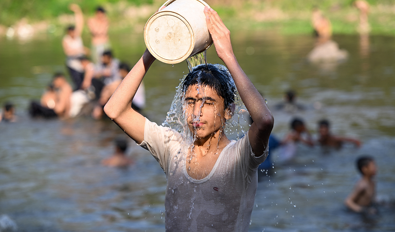 Boys bathe in the waters of Rawal dam on a hot summer day in Islamabad on May 23, 2024. (AFP/File)