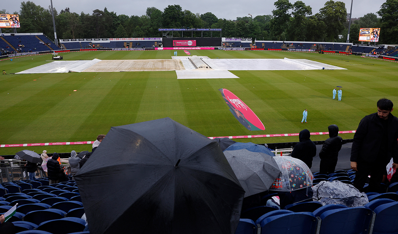 Spectators sit with umbrellas in the stand as rain delays the start of play between England and Pakistan at the Sophia Gardens Cricket Ground in Cardiff, Wales on May 28, 2024. (Reuters)