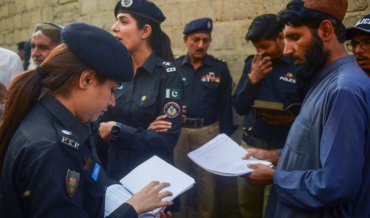Police officers check data of Afghan refugees during a search operation to identify alleged illegal immigrants, on the outskirts of Karachi on November 17, 2023. (AFP/File)