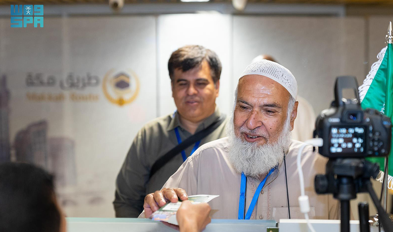 An official of Makkah Route handovers the passport of a pilgrim at immigration as he leaves for Saudi Arabia for the annual Hajj pilgrimage from Pakistan on May 20, 2024. (SPA)