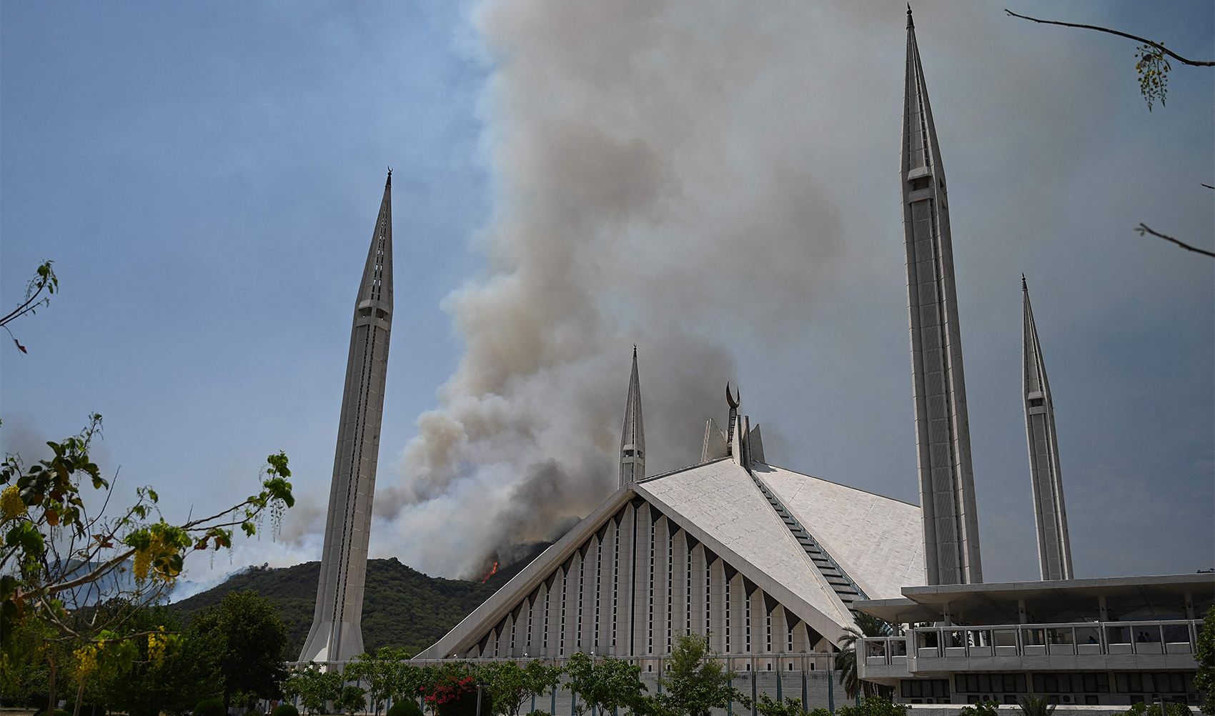 Smoke rises from a fire that erupted few days back in Margalla Hills forest near Faisal Mosque amid rising temperatures during a hot summer day in Islamabad on May 31, 2024. (AFP)