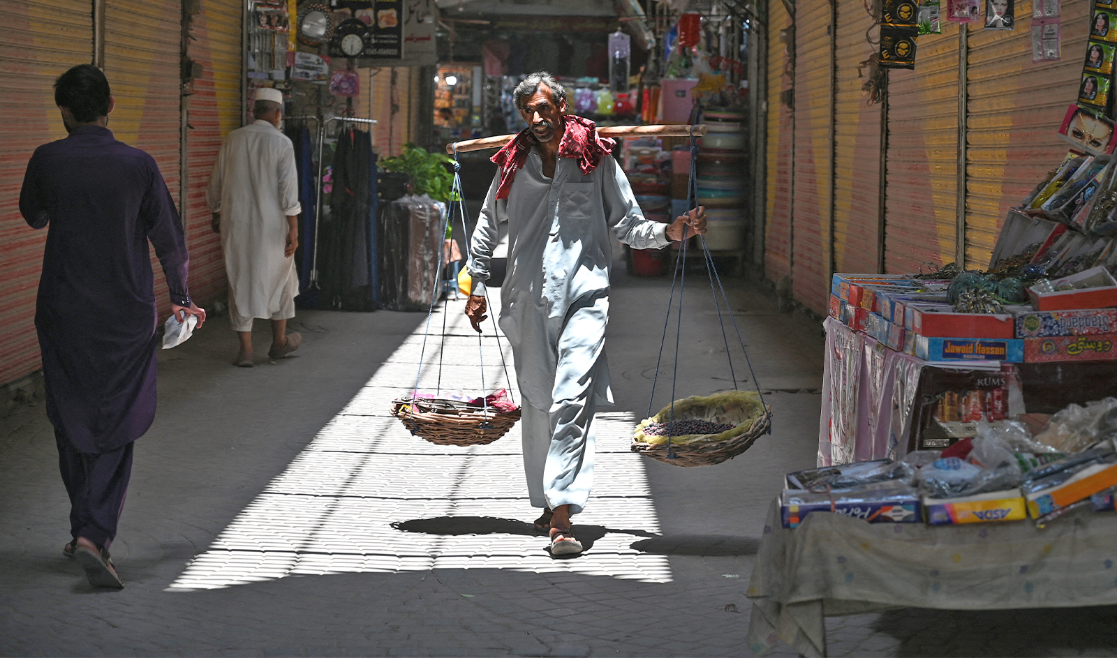 A street vendor selling phalsa fruits looks for customers along a market in Rawalpindi on June 9, 2023. (AFP/File)
