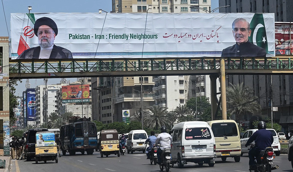 In this file photograph, taken on April 22, 2024, commuters ride past a welcoming billboard displaying an image of the Iranian president Ebrahim Raisi along a street in Karachi. (AFP)