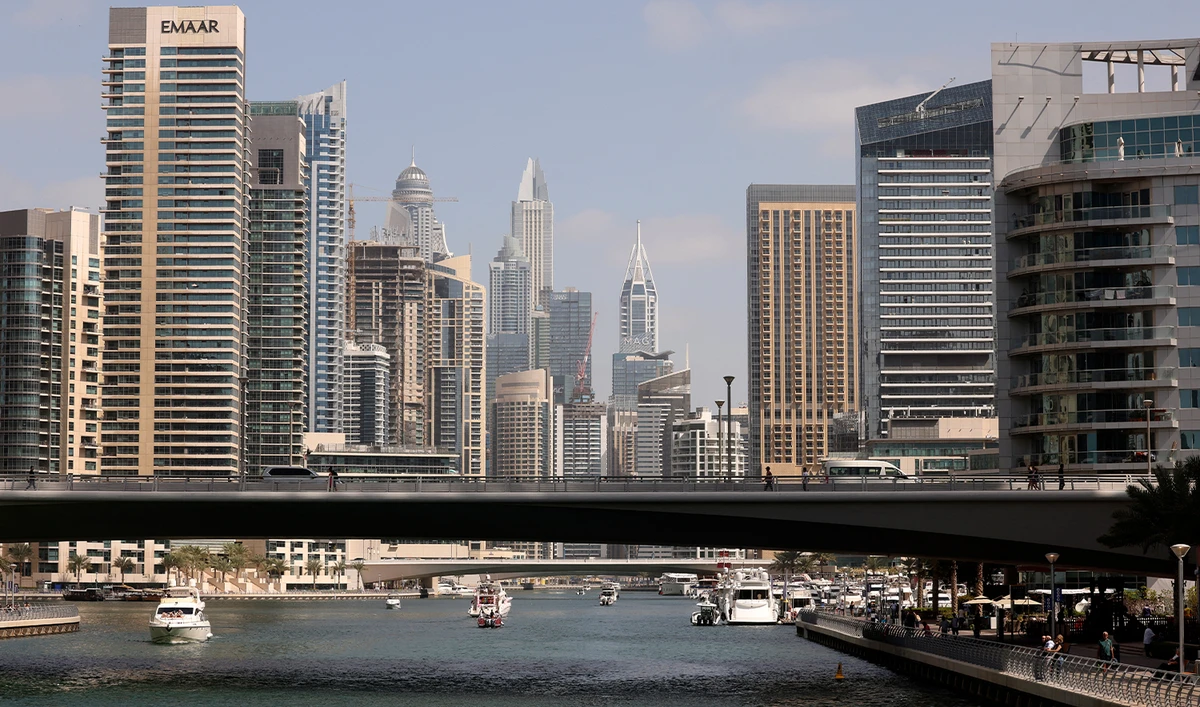 Boats sail along the Dubai Creek surrounded by high-rise buildings in the Gulf emirate, on February 18, 2023. (AFP/File)