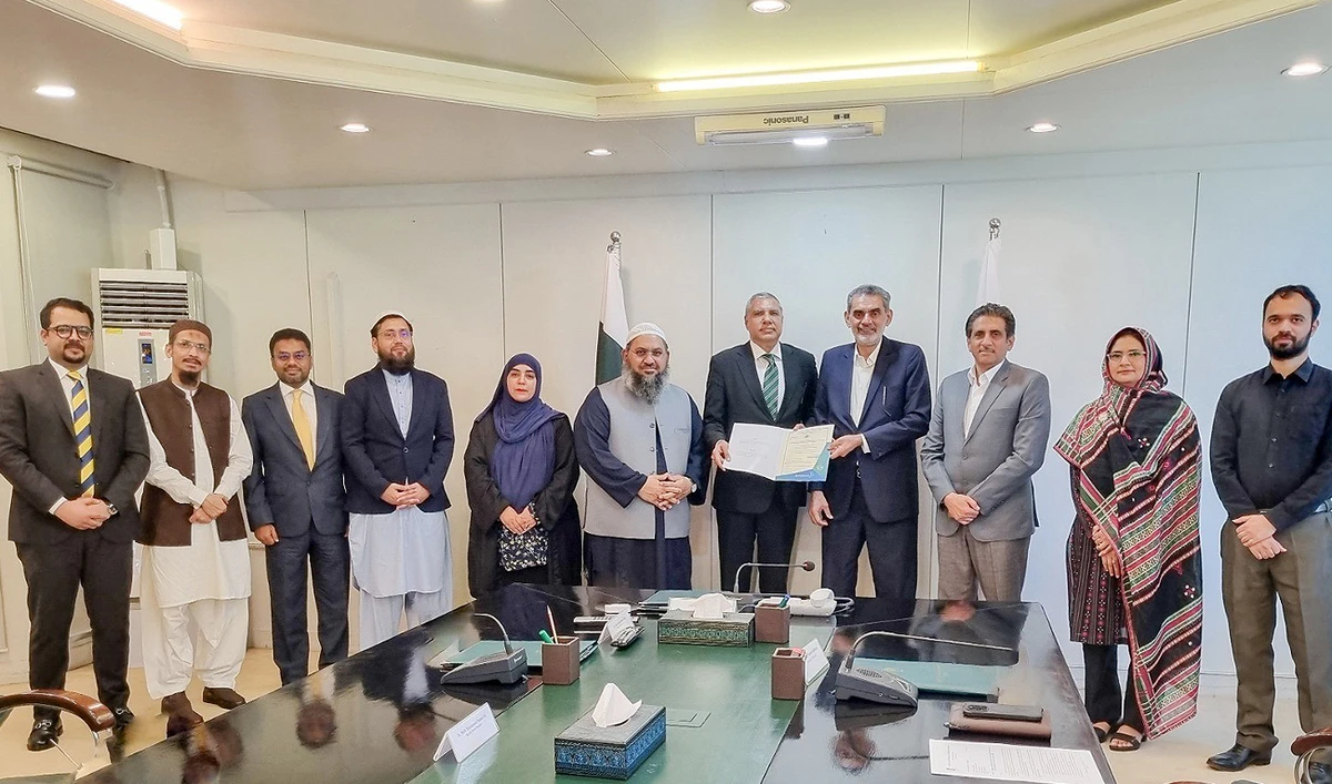 Officials pose for a group photograph as Akif Saeed, chairman of the Securities and Exchange Commission of Pakistan, handing over the license to Rizwan Hussain, chief executive officer of the Salaam Family Takaful Limited, for Pakistan’s “first ever” digital Islamic life insurance provider in Karachi on May 17, 2024. (APP)