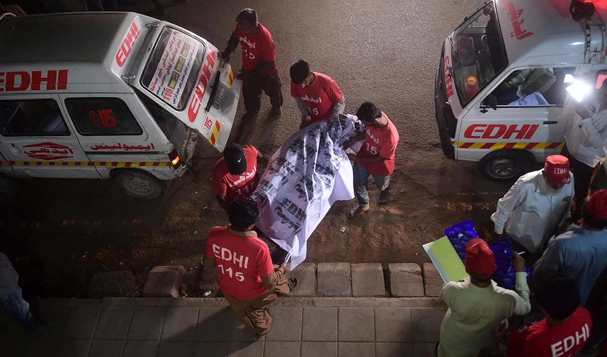 Edhi volunteers, a social welfare non-profit foundation, shift the remains of a victim to a morgue in Karachi early on October 13, 2022. (AFP/File)