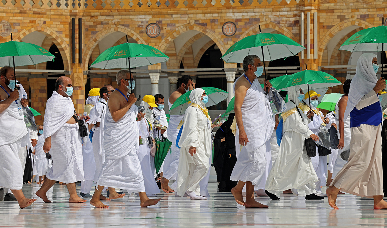 Pilgrims holding umrellas to protect themselves from the heat, arrive at the Kaaba, Islam's holiest shrine, at the Grand mosque in the holy city of Meccca, at the start of the Hajj season, on July 17, 2021. (AFP/File)