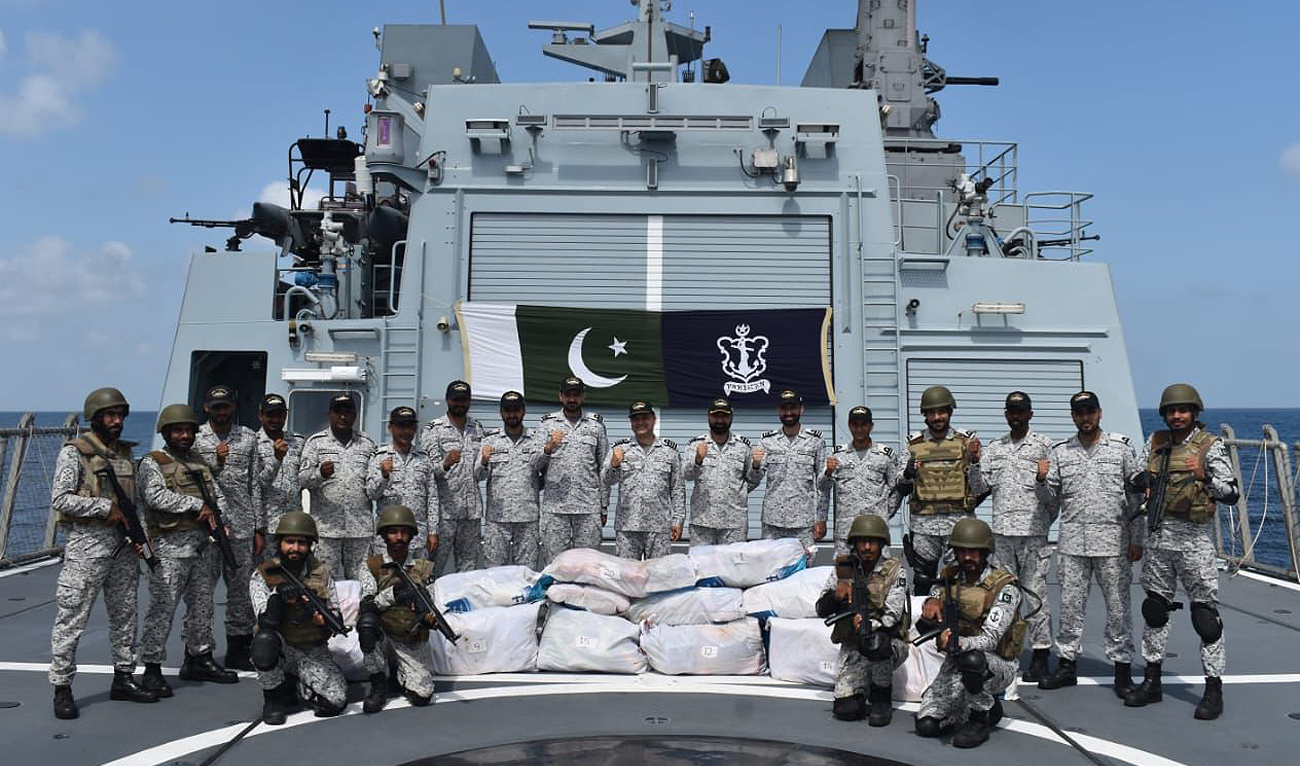 In this handout photograph, taken and released by Director General Public Relations Pakistan Navy, Navy personnel gesture for a group photo after a seizure of 380 kilograms of highly valuable drugs in an operation in North Arabian Sea. (Photo courtesy: Pakistan Navy)
