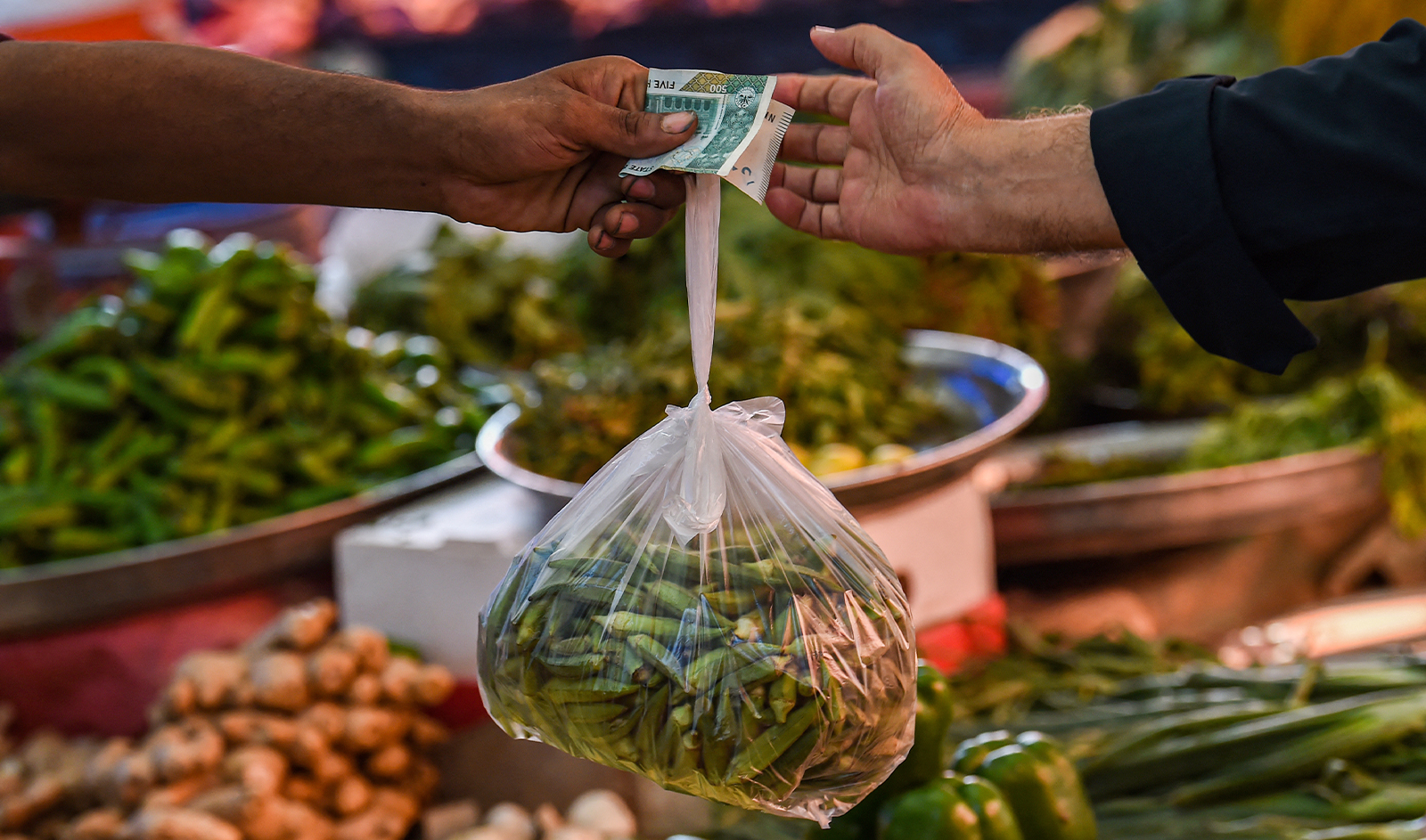 A customer buys vegetables from a stall at a market in Karachi on July 3, 2023. (AFP/File)