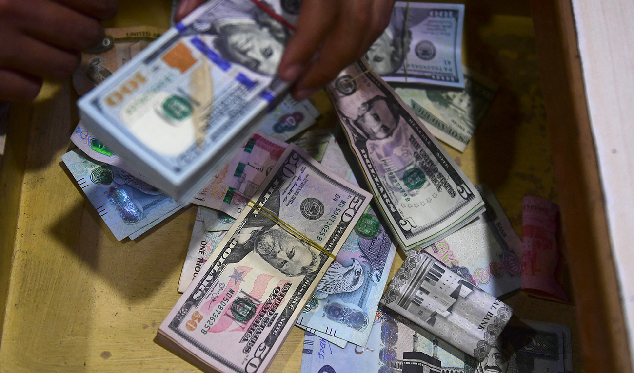 A dealer collect US dollars at a money exchange market in Karachi on January 26, 2023. (AFP/File)