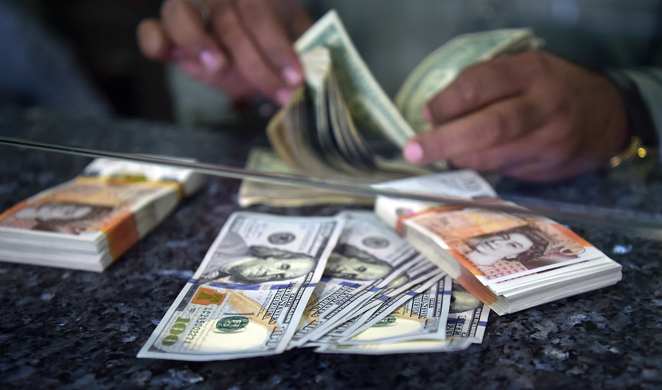 A Pakistani dealer counts US dollars at a currency exchange shop in Islamabad on October 9, 2018. (AFP/File)