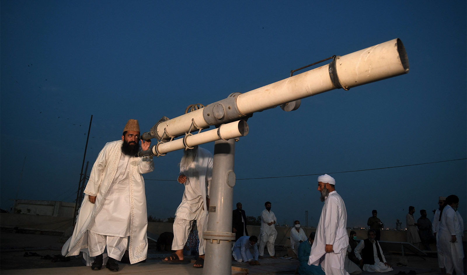 A member of Pakistan Ramadan moon-sighting committee, looks through a telescope for the new moon that signals the start of the Muslim fasting month of Ramadan in Karachi on April 23, 2020. (AFP/File)
