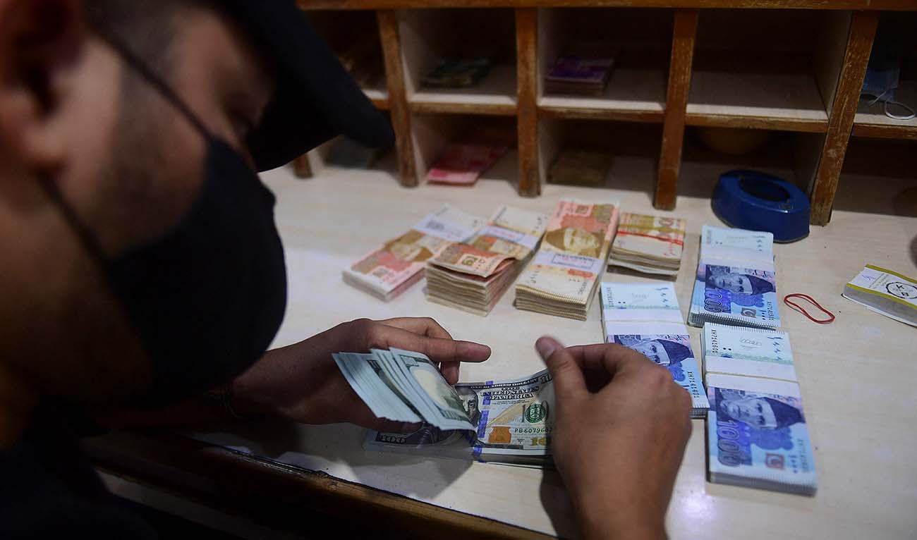 In this picture taken on January 11, 2022, a foreign currency dealer counts US dollar notes at a shop in Karachi. (AFP/File)