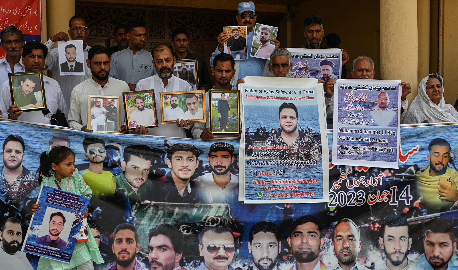 Family members hold photos of the victims of last year's Greece shipwreck tragedy as they gather to mark its first anniversary, in Lalamusa a town in Punjab province on June 14, 2024. (AFP)
