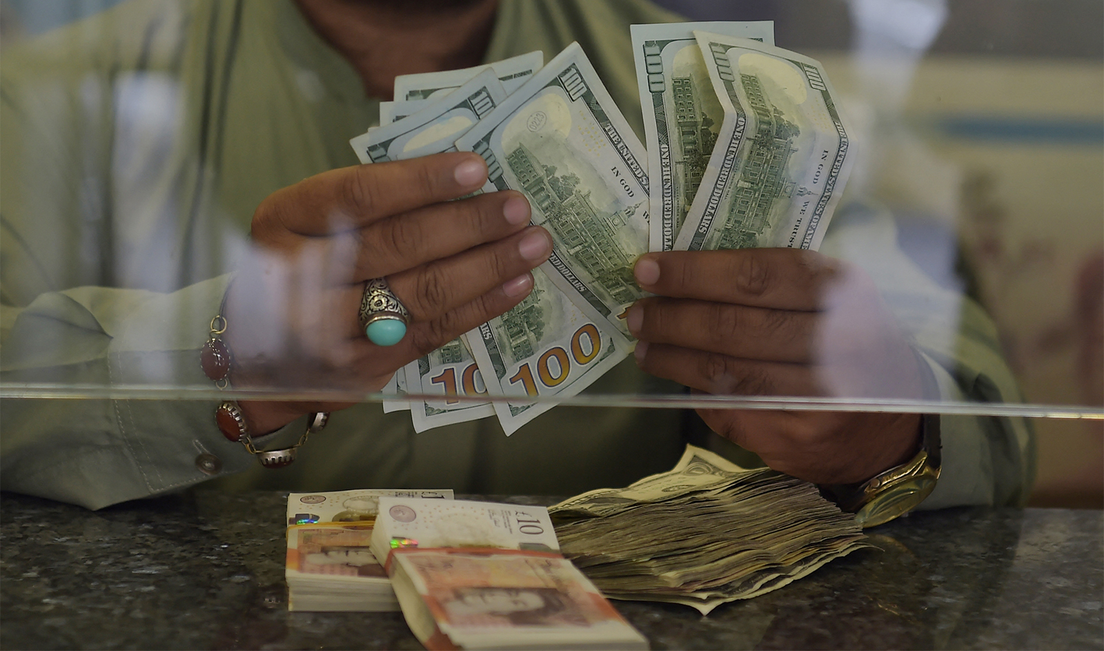 A Pakistani dealer counts US dollars at a currency exchange shop in Islamabad on October 9, 2018. (AFP/File)