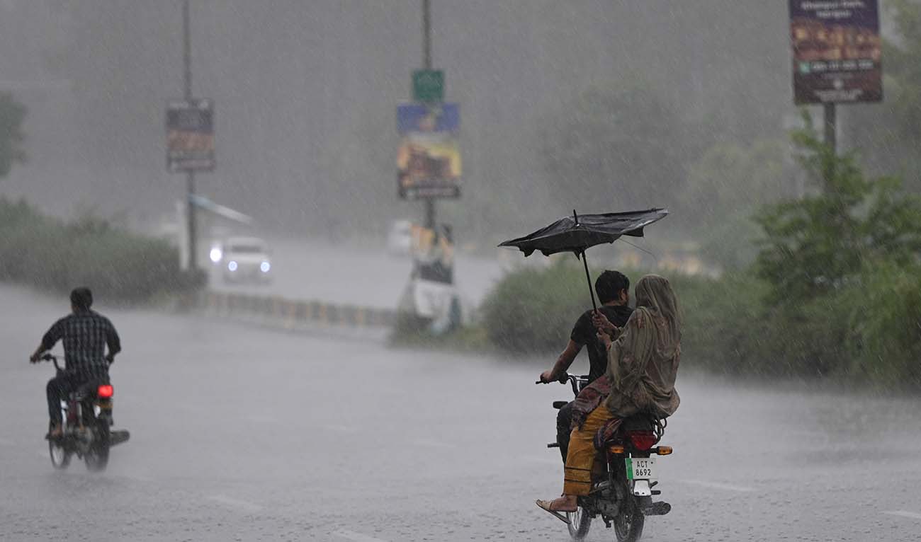 Commuters make their way along a motorway during a heavy rainfall in Islamabad on August 17, 2023. (AFP/File)