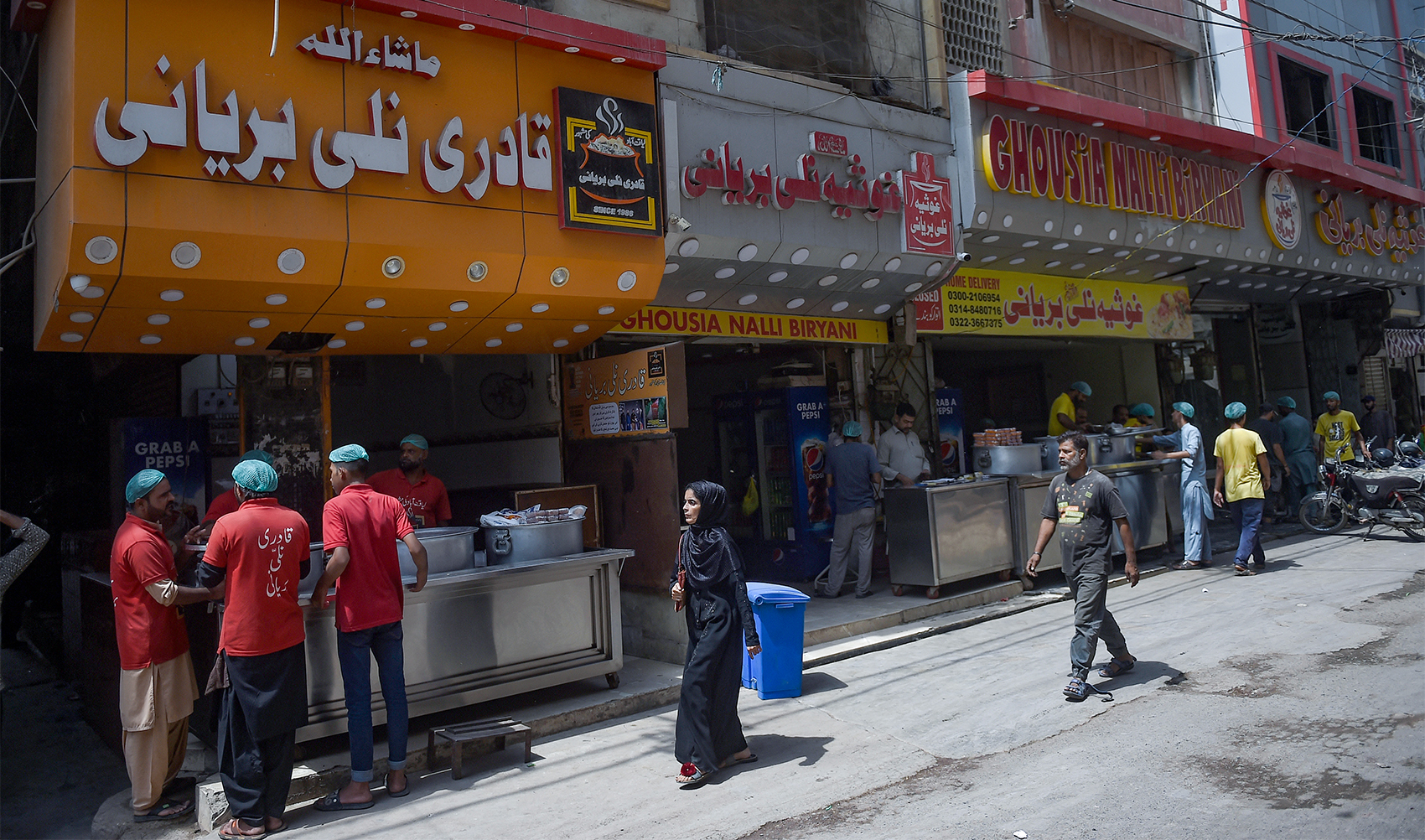 In this photograph taken on September 16, 2023, 'Qadri Nalli Biryani' and 'Ghousia Nalli Biryani' restaurants are seen adjacent to each other along a street in Karachi. (AFP/File)