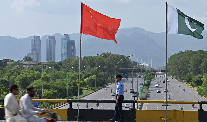 A policeman stands guard under the national flags of China and Pakistan along a road ahead of the visit of Chinese Vice Premier He Lifeng, in Islamabad on July 30, 2023. (AFP/File)