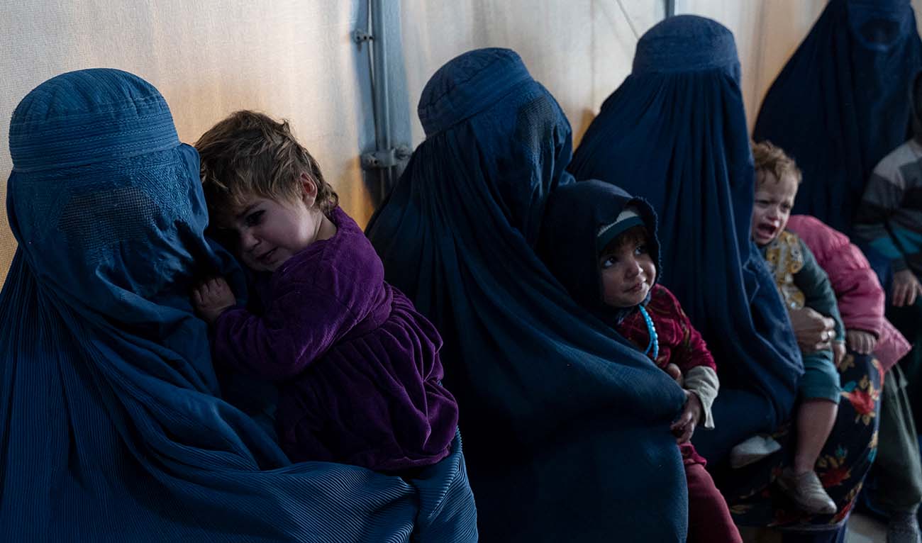 This photograph taken on January 9, 2024 shows Afghan burqa-clad women and children refugees deported from Pakistan, in a nutrition ward at the United Nations High Commissioner for Refugees (UNHCR) camp on the outskirts of Kabul. (AFP/File)