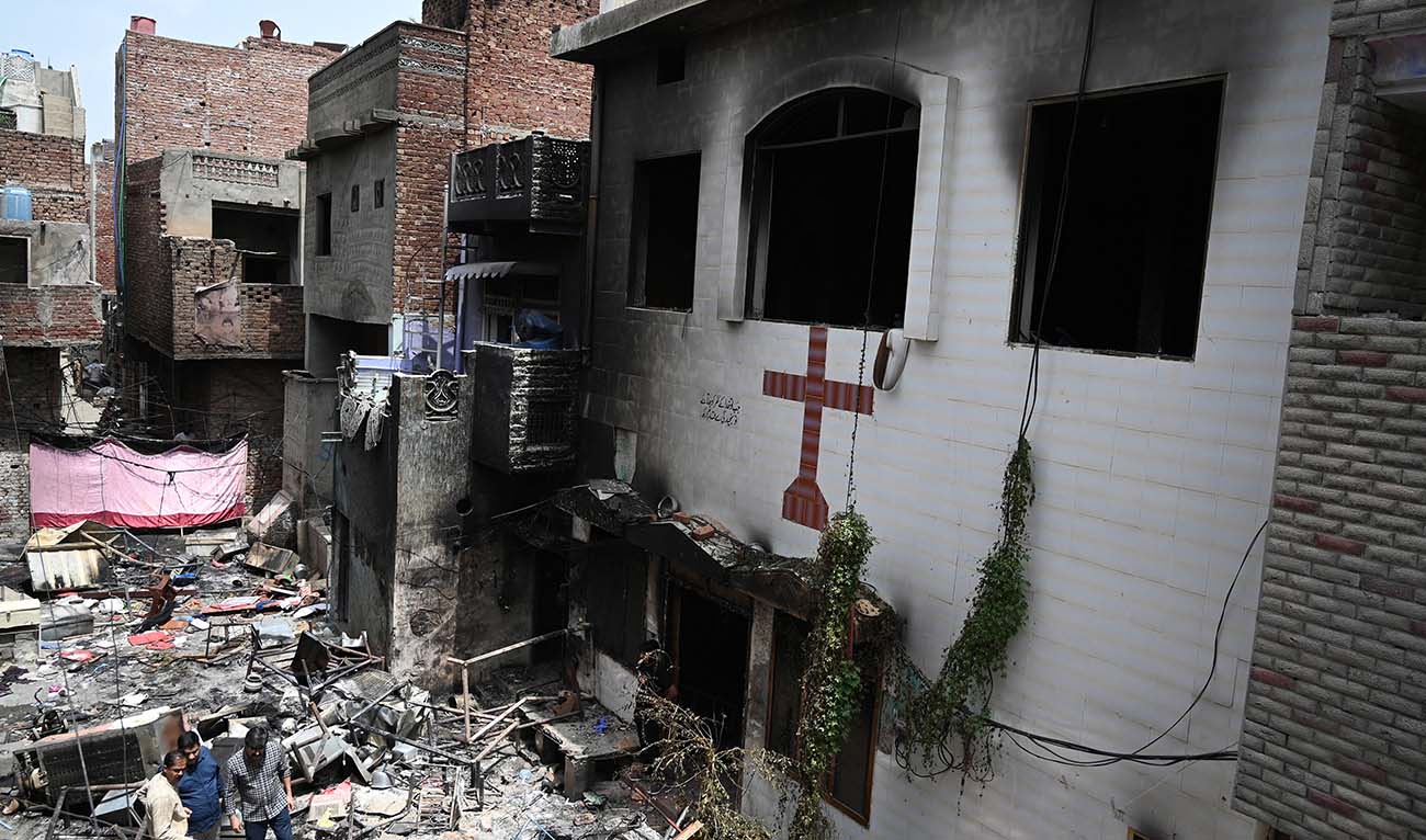 Men stand amid debris outside the torched Saint John Church in Jaranwala on the outskirts of Faisalabad on August 17, 2023, a day after an attack by Muslim men following spread allegations that Christians had desecrated the Koran. (AFP/File)