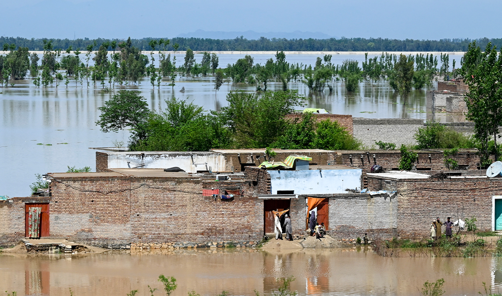 People stand at their deluged houses after heavy rains in Nowshera district, Khyber-Pakhtunkhwa province on April 16, 2024. (AFP/File)