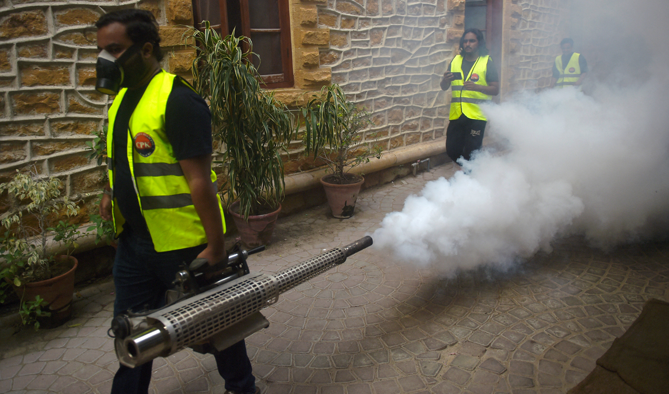 A worker fumigates a street as a preventive measure against diseases-carrying mosquitoes during the monsoon season in Karachi on September 25, 2022. (AFP)