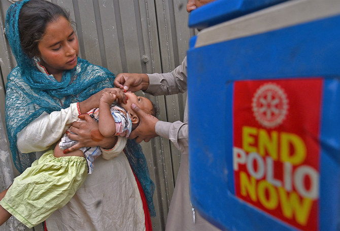 A health worker administers polio vaccine drops to a child during a door-to-door polio vaccination campaign in Lahore, Pakistan, on May 23, 2022. (AFP/File)
